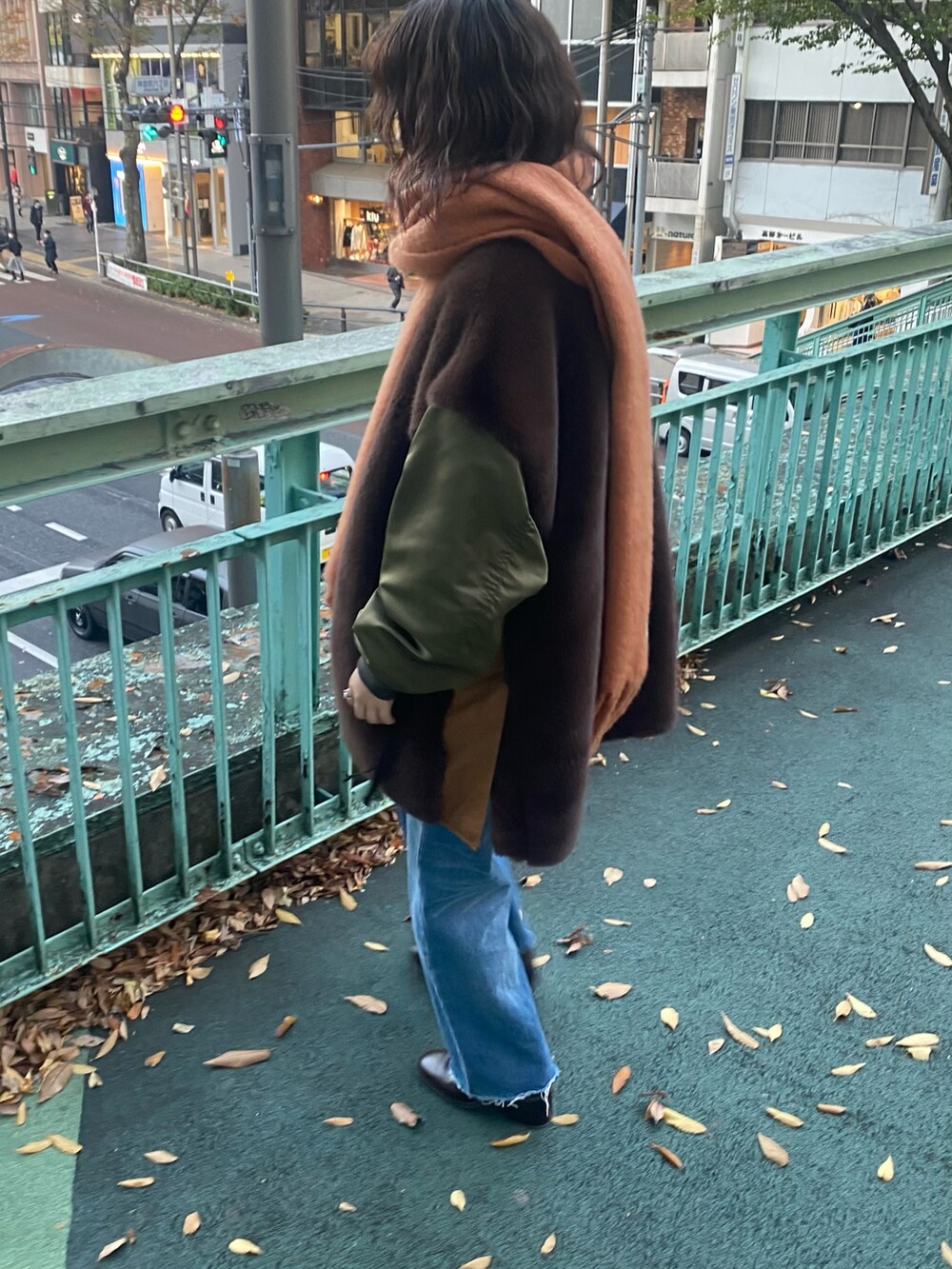 ブラウン系のその他アウター、ブルー系のデニムパンツ、オレンジ系のショルダーバッグを着用したレディースの秋コーディネートの2枚目の写真