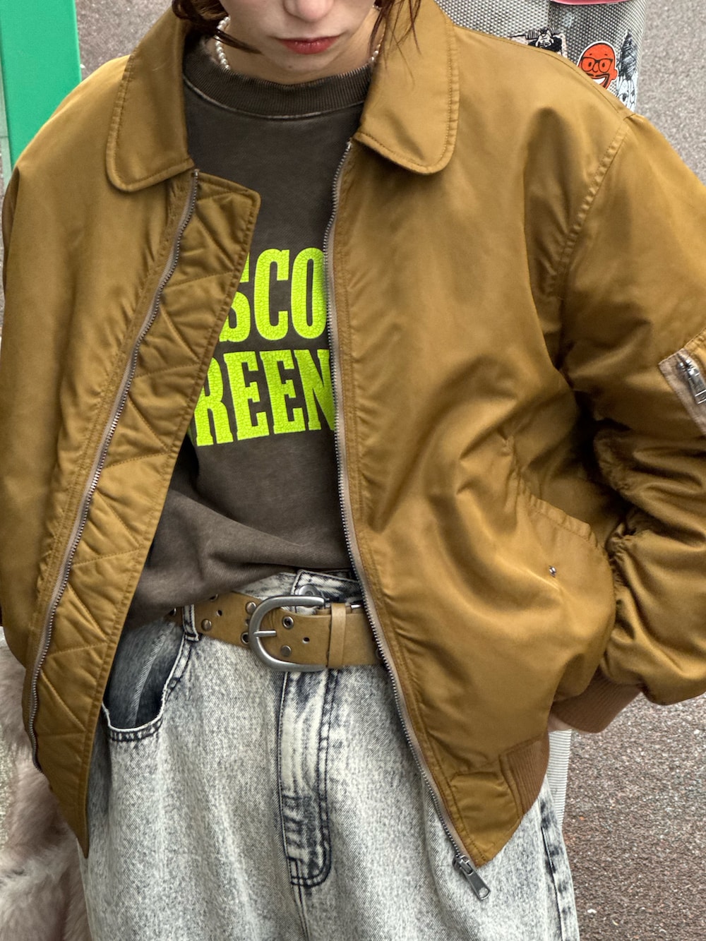 ブラウン系のスウェット、ブラック系のデニムパンツ、ベージュ系のショルダーバッグを着用したレディースの秋コーディネートの2枚目の写真