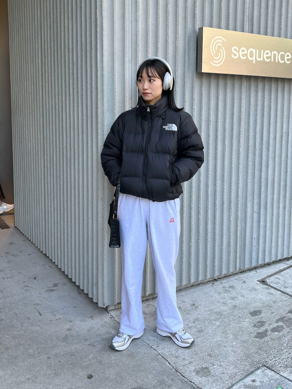 ブラック系のダウンジャケット/コート、グレー系のスウェットパンツ、シルバー系のスニーカーを着用したレディースの秋コーディネートの5枚目の写真