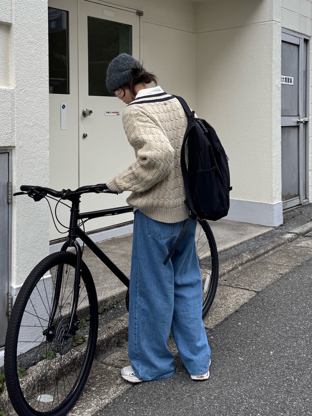 ベージュ系のニット/セーター、ホワイト系のシャツ/ブラウス、ブルー系のデニムパンツを着用したレディースの秋コーディネートの2枚目の写真