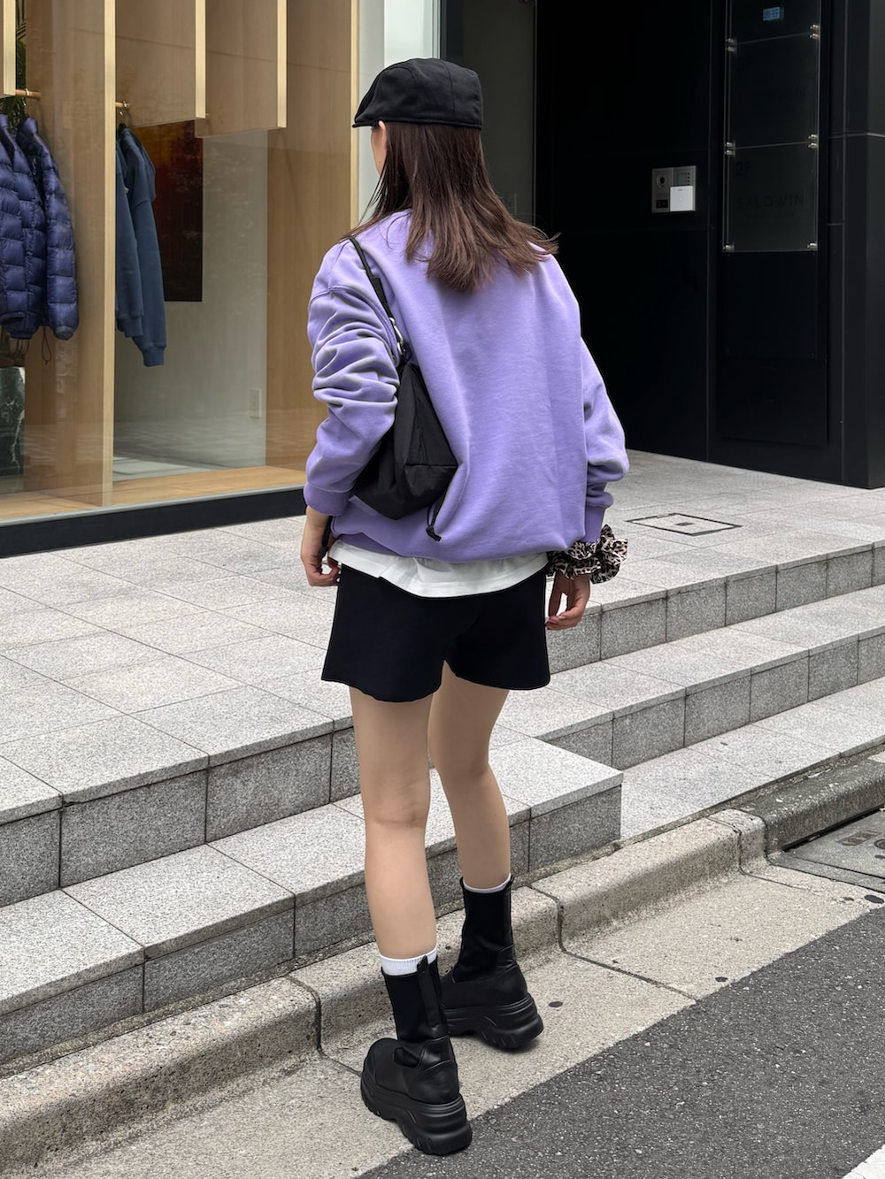 パープル系のスウェット、ブラック系のブーツを着用したレディースの秋コーディネートの2枚目の写真