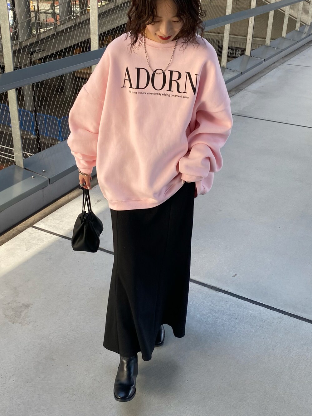 ホワイト系のスウェット、グレー系のスカート、ブラック系のショルダーバッグを着用したレディースの秋コーディネートの3枚目の写真