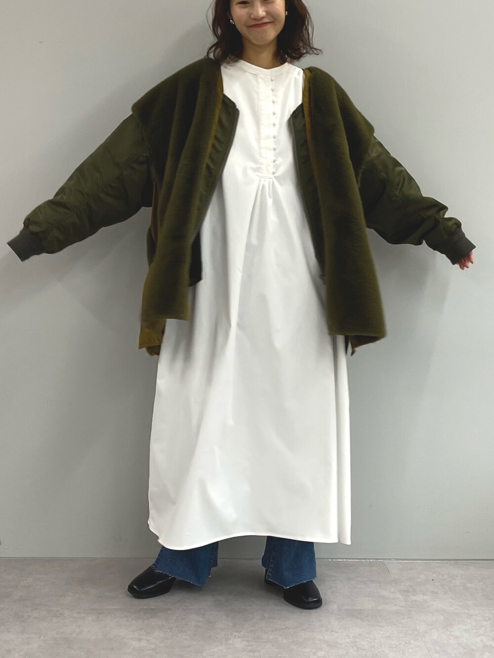 ホワイト系のワンピース、グリーン系のその他アウターを着用したレディースの冬コーディネートの2枚目の写真