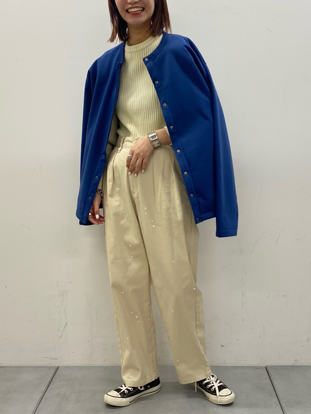 ホワイト系のニット/セーター、ブラック系のカーディガン/ボレロ、ホワイト系のチノパンツを着用したレディースの秋コーディネートの2枚目の写真