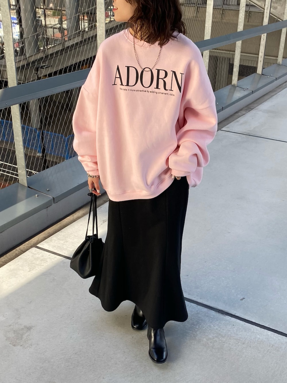 ホワイト系のスウェット、グレー系のスカート、ブラック系のショルダーバッグを着用したレディースの秋コーディネートの2枚目の写真