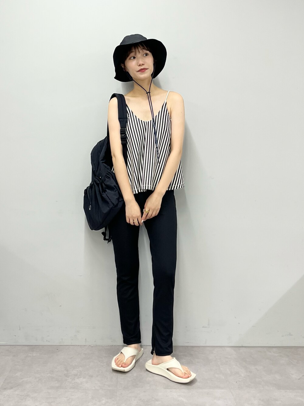 ブラック系のバックパック/リュック、ベージュ系のサンダル、グレー系のハットを着用したレディースの夏コーディネートの2枚目の写真