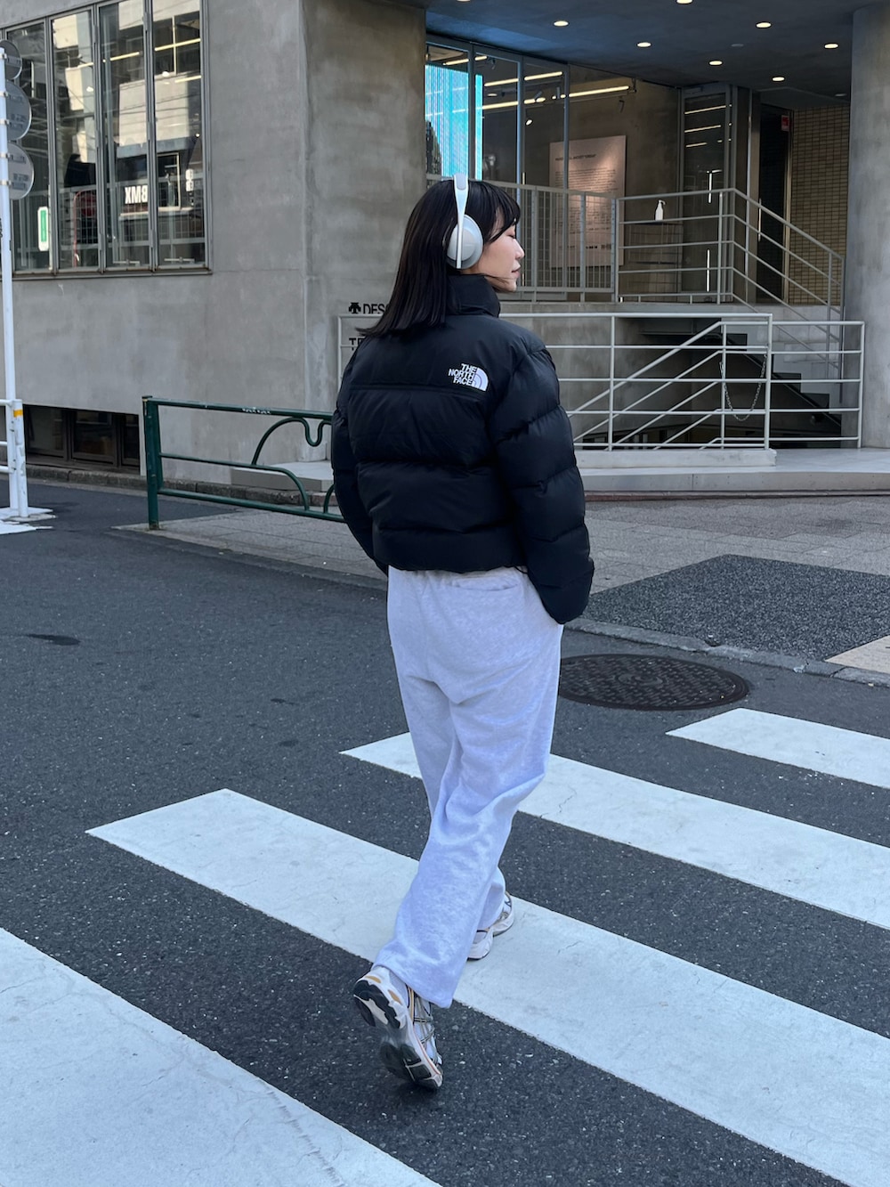 ブラック系のダウンジャケット/コート、グレー系のスウェットパンツ、シルバー系のスニーカーを着用したレディースの秋コーディネートの4枚目の写真