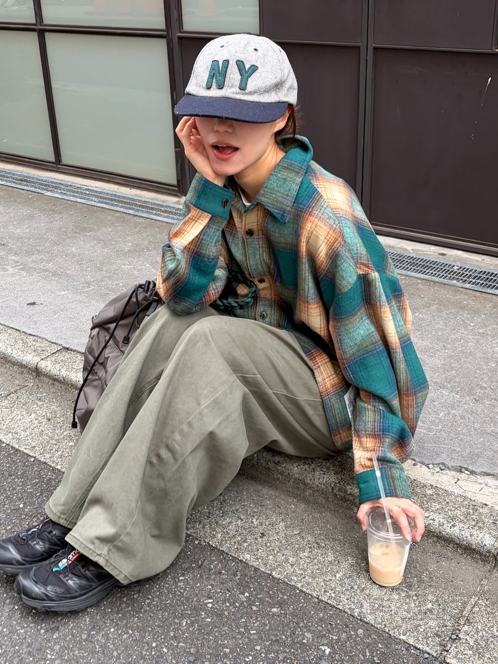 グリーン系のシャツ/ブラウス、グレー系のデニムパンツ、グレー系のバックパック/リュックを着用したレディースの秋コーディネートの4枚目の写真