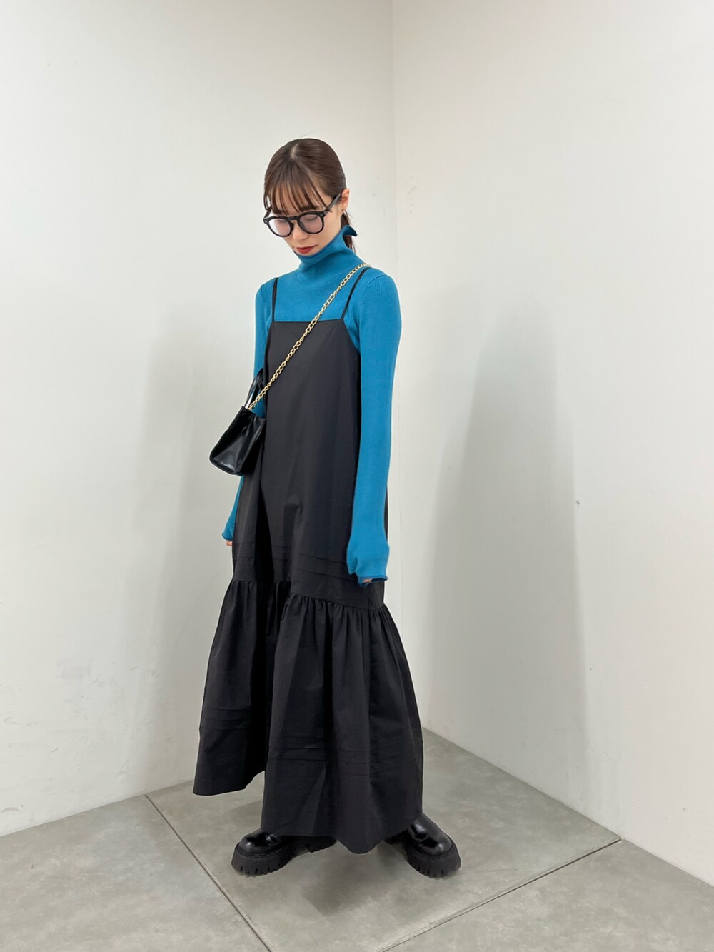 ブルー系のニット/セーター、ブラック系のワンピース、ブラック系のショルダーバッグを着用したレディースの冬コーディネートの3枚目の写真