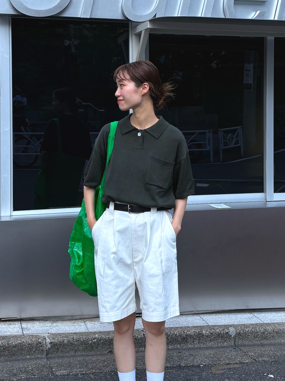 グリーン系のポロシャツ、ホワイト系のデニムパンツを着用したレディースの夏コーディネートの3枚目の写真