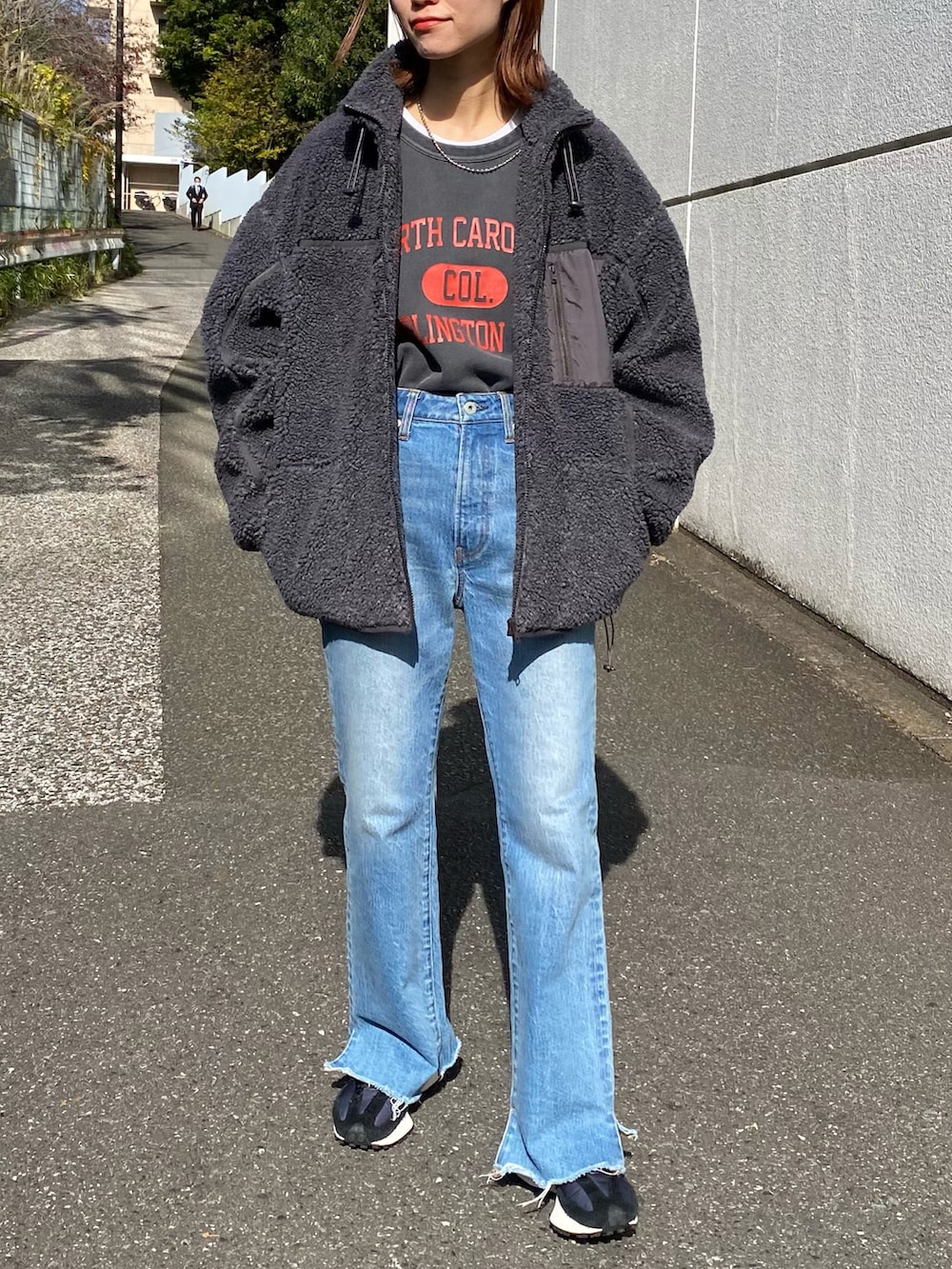 グレー系のスウェット、イエロー系のその他アウター、ブルー系のデニムパンツを着用したレディースの冬コーディネートの2枚目の写真