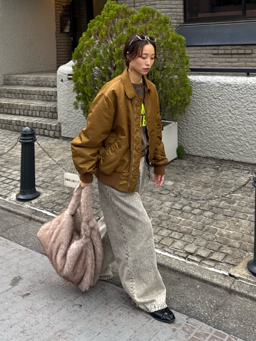 ブラウン系のスウェット、ブラック系のデニムパンツ、ベージュ系のショルダーバッグを着用したレディースの秋コーディネートの3枚目の写真