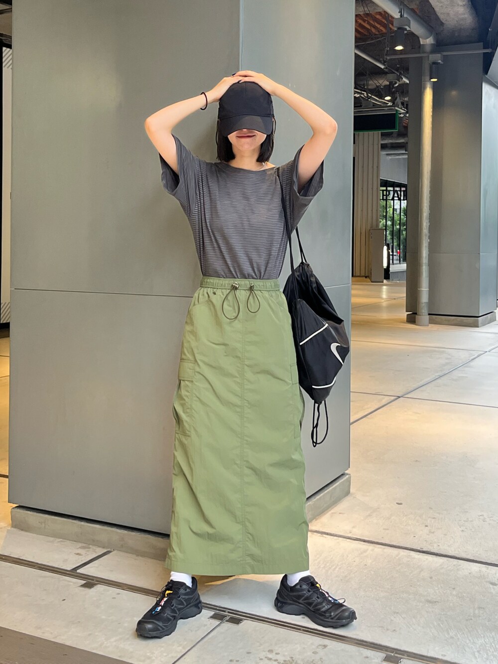 グレー系のTシャツ/カットソー、グリーン系のスカート、ブラック系のスニーカーを着用したレディースの夏コーディネートの3枚目の写真