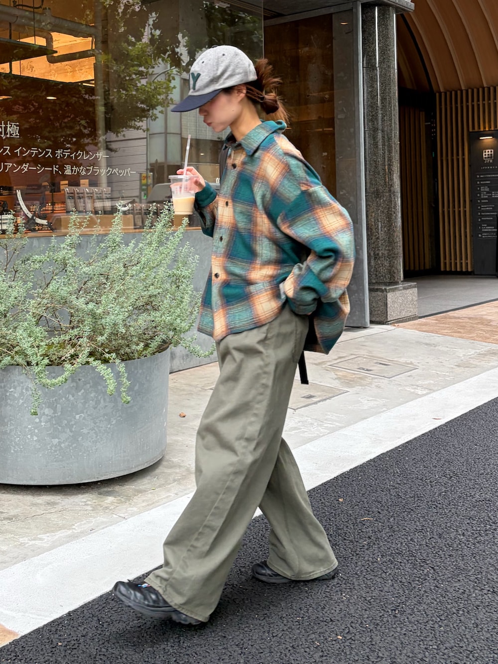 グリーン系のシャツ/ブラウス、グレー系のデニムパンツ、グレー系のバックパック/リュックを着用したレディースの秋コーディネートの2枚目の写真