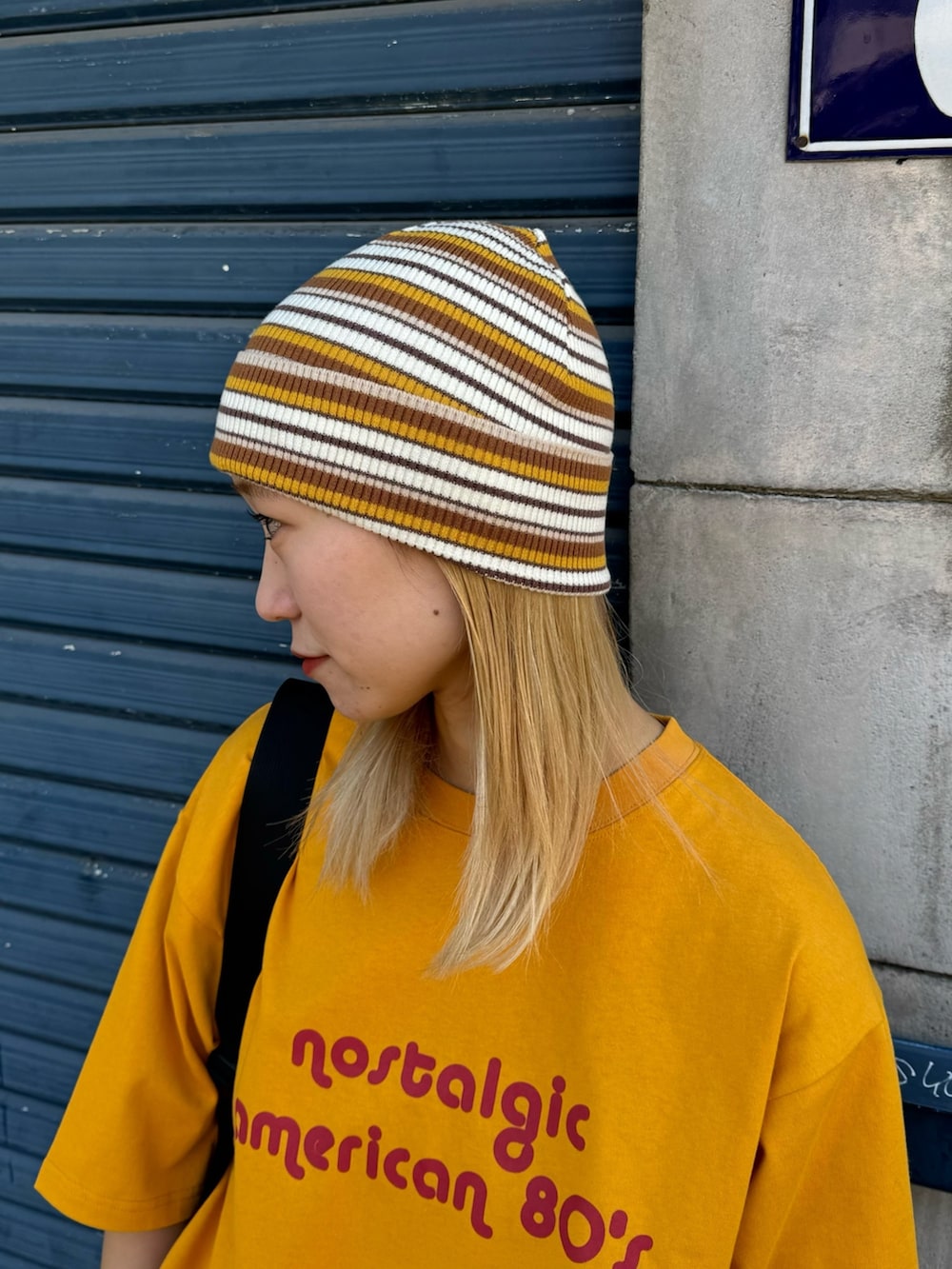 イエロー系のTシャツ/カットソー、ブラック系のカーゴパンツ、ブラック系のバックパック/リュックを着用したレディースの春コーディネートの3枚目の写真