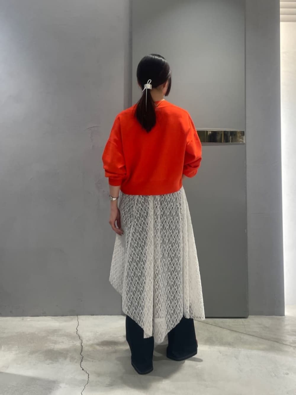 オレンジ系のTシャツ/カットソー、ブルー系のデニムパンツを着用したレディースの春コーディネートの3枚目の写真