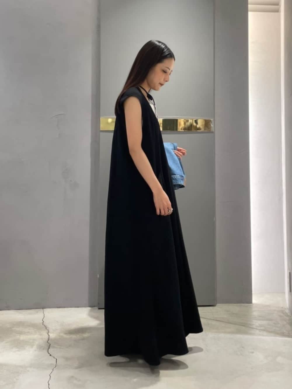 ブラック系のワンピースを着用したレディースの春コーディネートの2枚目の写真