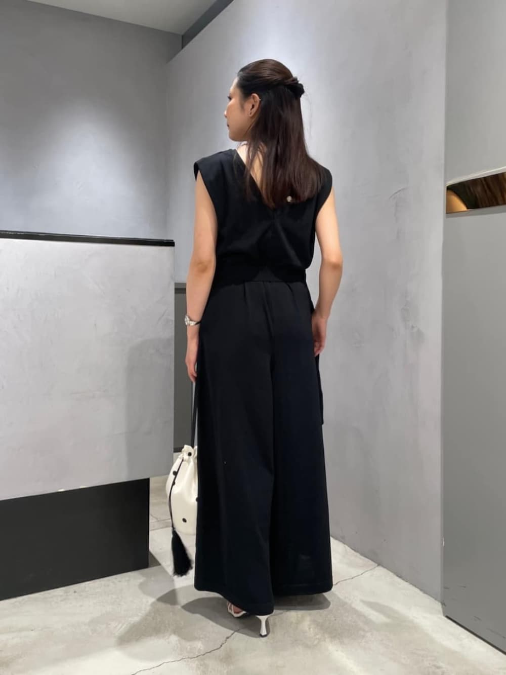 ホワイト系のハンドバッグ、ブラック系のサロペット/オーバーオールを着用したレディースの春コーディネートの2枚目の写真