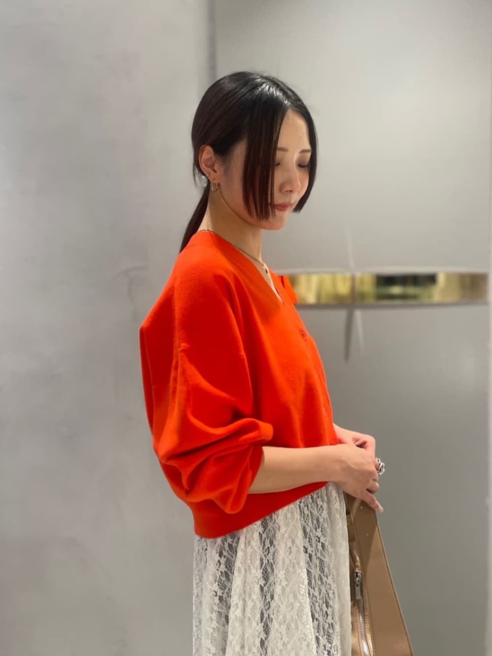 オレンジ系のTシャツ/カットソー、ブルー系のデニムパンツを着用したレディースの春コーディネートの5枚目の写真