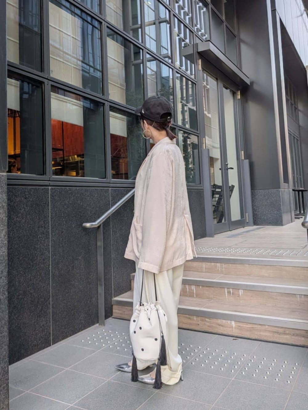 ホワイト系のテーラードジャケット、ホワイト系のその他パンツ、ホワイト系のハンドバッグを着用したレディースの春コーディネートの2枚目の写真