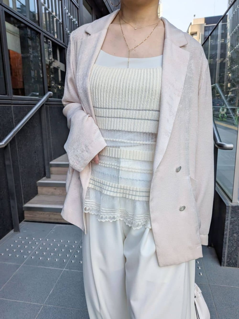 ホワイト系のテーラードジャケット、ホワイト系のその他パンツ、ホワイト系のハンドバッグを着用したレディースの春コーディネートの5枚目の写真