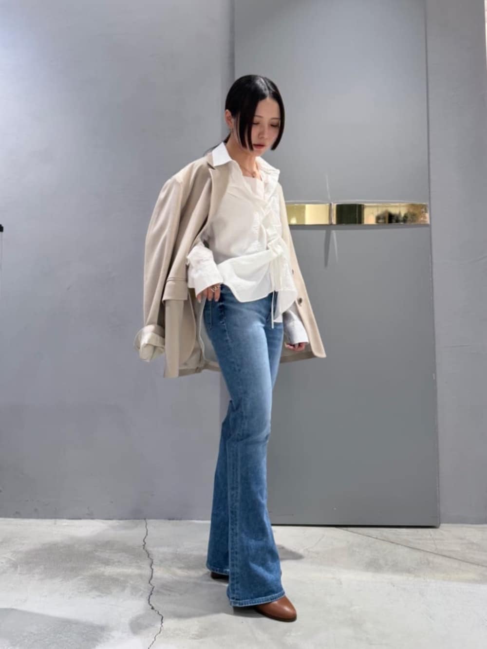 ブルー系のデニムパンツ、ホワイト系のシャツ/ブラウス、ベージュ系のテーラードジャケットを着用したレディースの春コーディネートの3枚目の写真