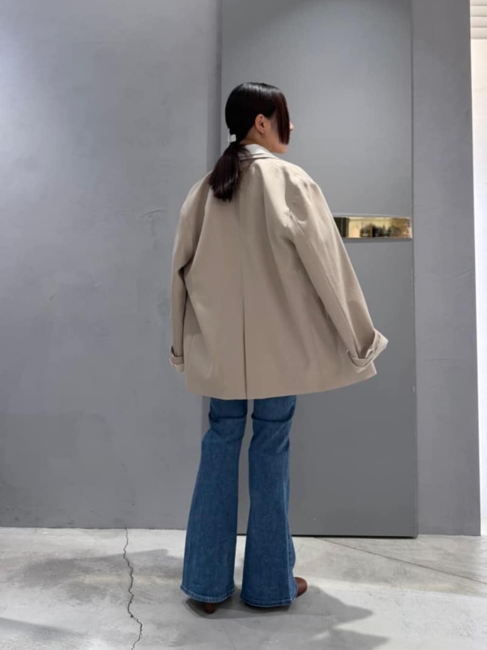 ブルー系のデニムパンツ、ホワイト系のシャツ/ブラウス、ベージュ系のテーラードジャケットを着用したレディースの春コーディネートの4枚目の写真