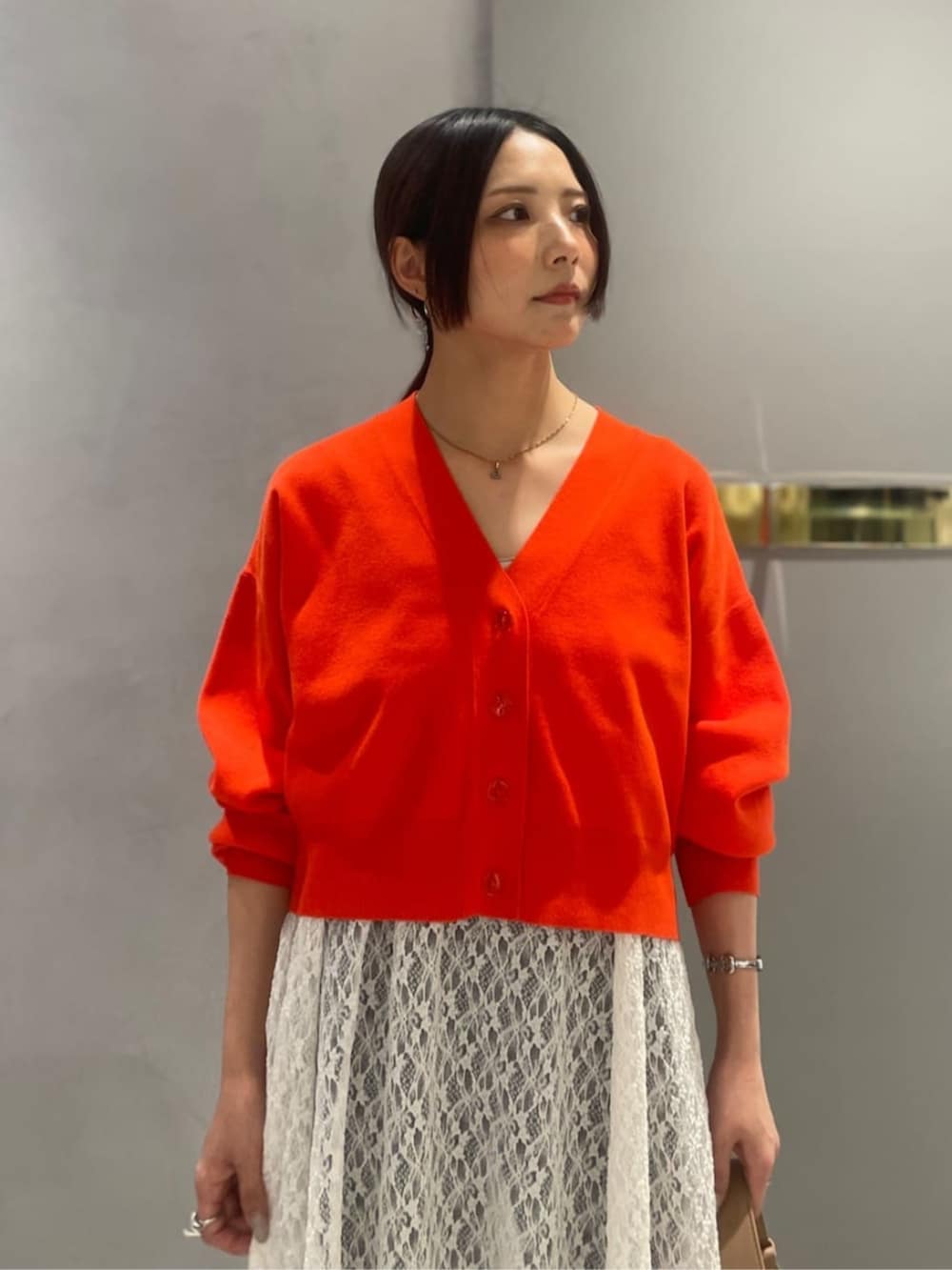 オレンジ系のTシャツ/カットソー、ブルー系のデニムパンツを着用したレディースの春コーディネートの4枚目の写真