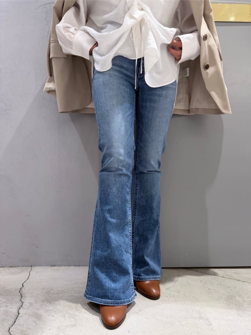 ブルー系のデニムパンツ、ホワイト系のシャツ/ブラウス、ベージュ系のテーラードジャケットを着用したレディースの春コーディネートの7枚目の写真