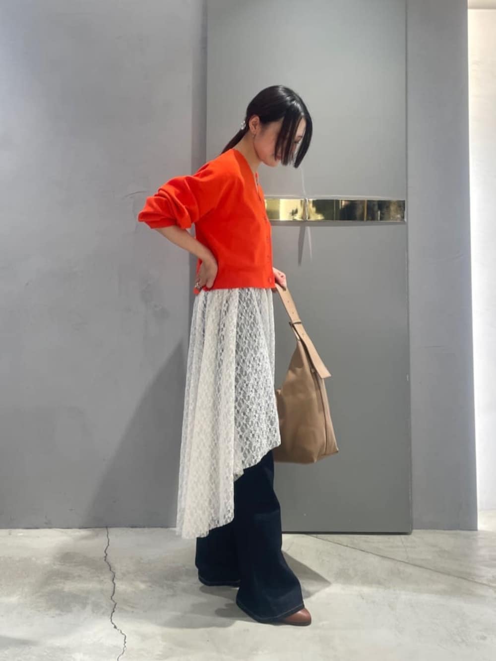 オレンジ系のTシャツ/カットソー、ブルー系のデニムパンツを着用したレディースの春コーディネートの2枚目の写真