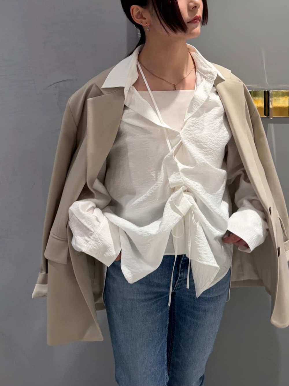 ブルー系のデニムパンツ、ホワイト系のシャツ/ブラウス、ベージュ系のテーラードジャケットを着用したレディースの春コーディネートの5枚目の写真