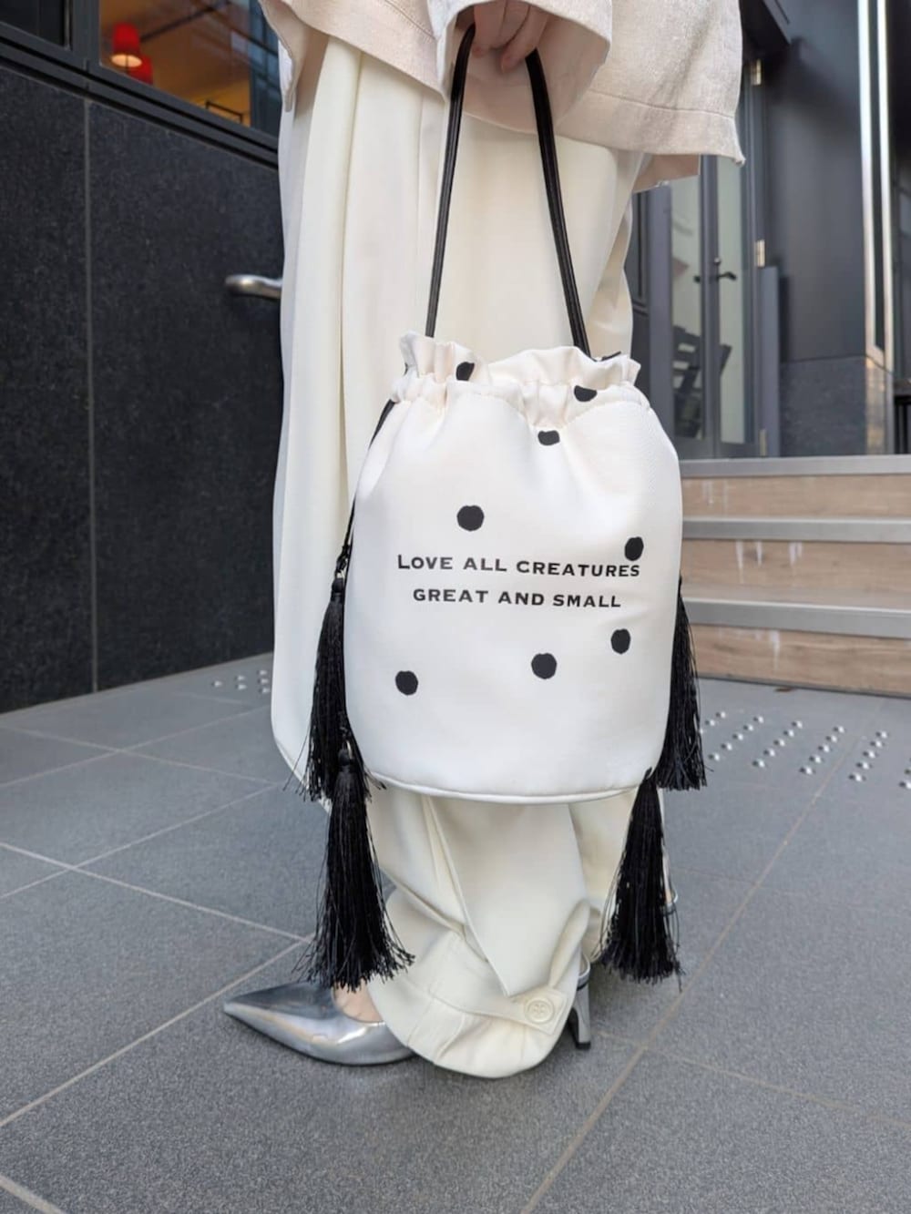 ホワイト系のテーラードジャケット、ホワイト系のその他パンツ、ホワイト系のハンドバッグを着用したレディースの春コーディネートの7枚目の写真