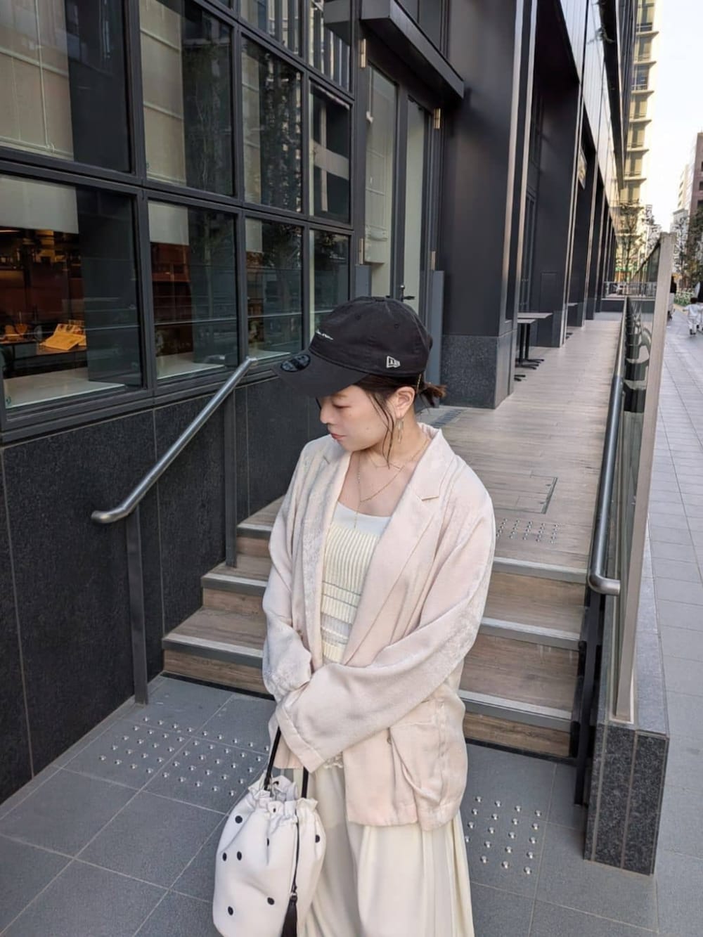 ホワイト系のテーラードジャケット、ホワイト系のその他パンツ、ホワイト系のハンドバッグを着用したレディースの春コーディネートの4枚目の写真