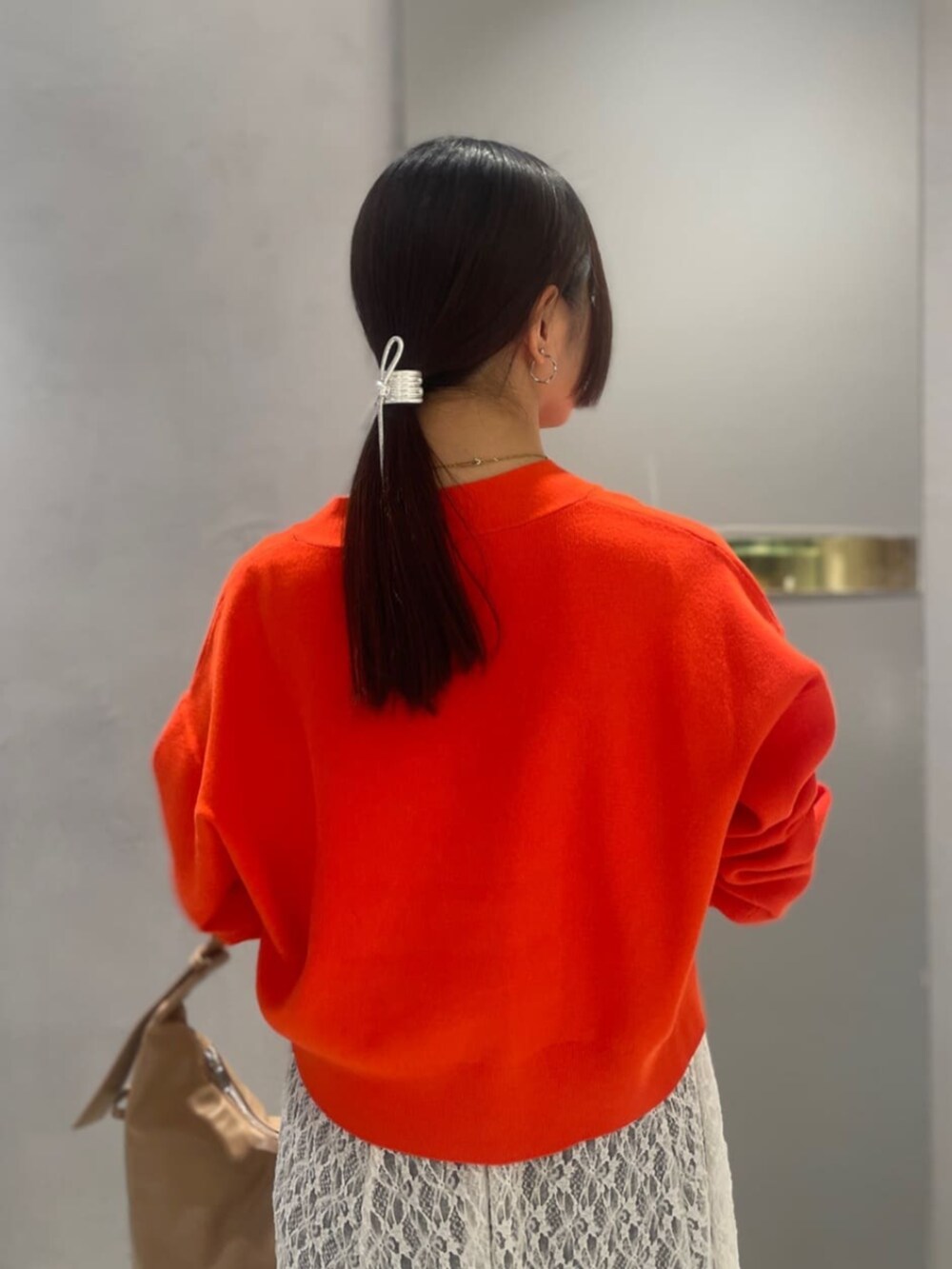 オレンジ系のTシャツ/カットソー、ブルー系のデニムパンツを着用したレディースの春コーディネートの6枚目の写真