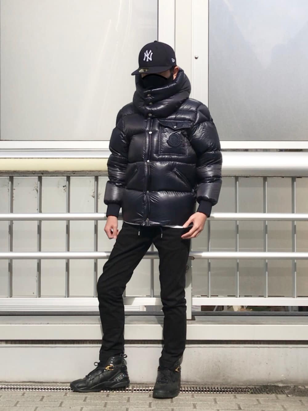 ブラック系のダウンジャケット/コート、ホワイト系のTシャツ/カットソー、ブラック系のボディバッグ/ウエストポーチを着用したメンズの冬コーディネートの2枚目の写真