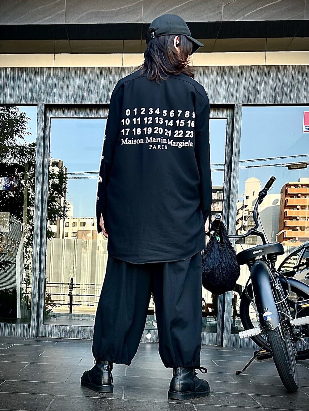 ブラック系のパンツ、ブラック系のブーツ、ブラック系のキャップを着用したメンズの秋コーディネートの4枚目の写真