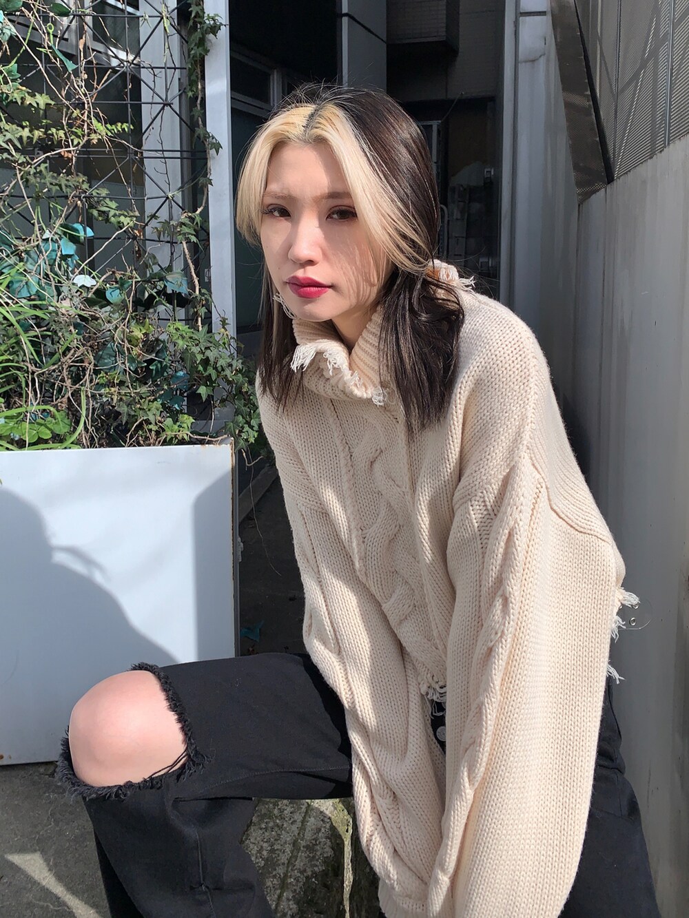 ブラック系のデニムパンツ、ホワイト系のニット/セーターを着用したレディースの冬コーディネートの4枚目の写真