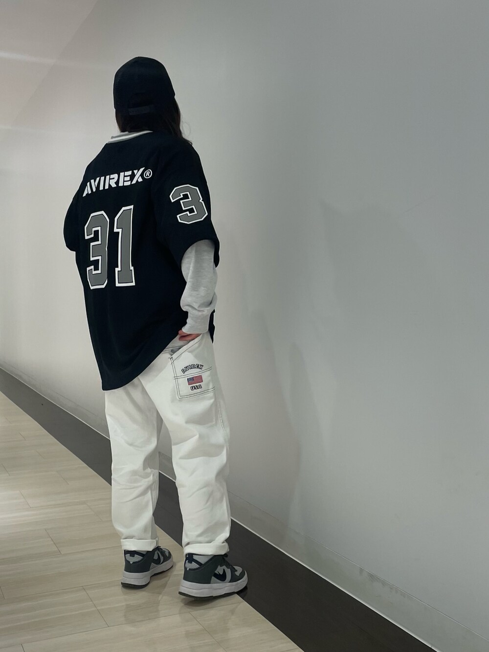 ホワイト系のデニムパンツ、グレー系のスウェット、ブラック系のキャップを着用したレディースの冬コーディネートの2枚目の写真