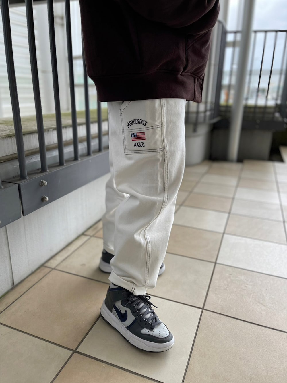 ブラック系のスウェット、ホワイト系のデニムパンツ、イエロー系のニットキャップ/ビーニーを着用したレディースの冬コーディネートの2枚目の写真