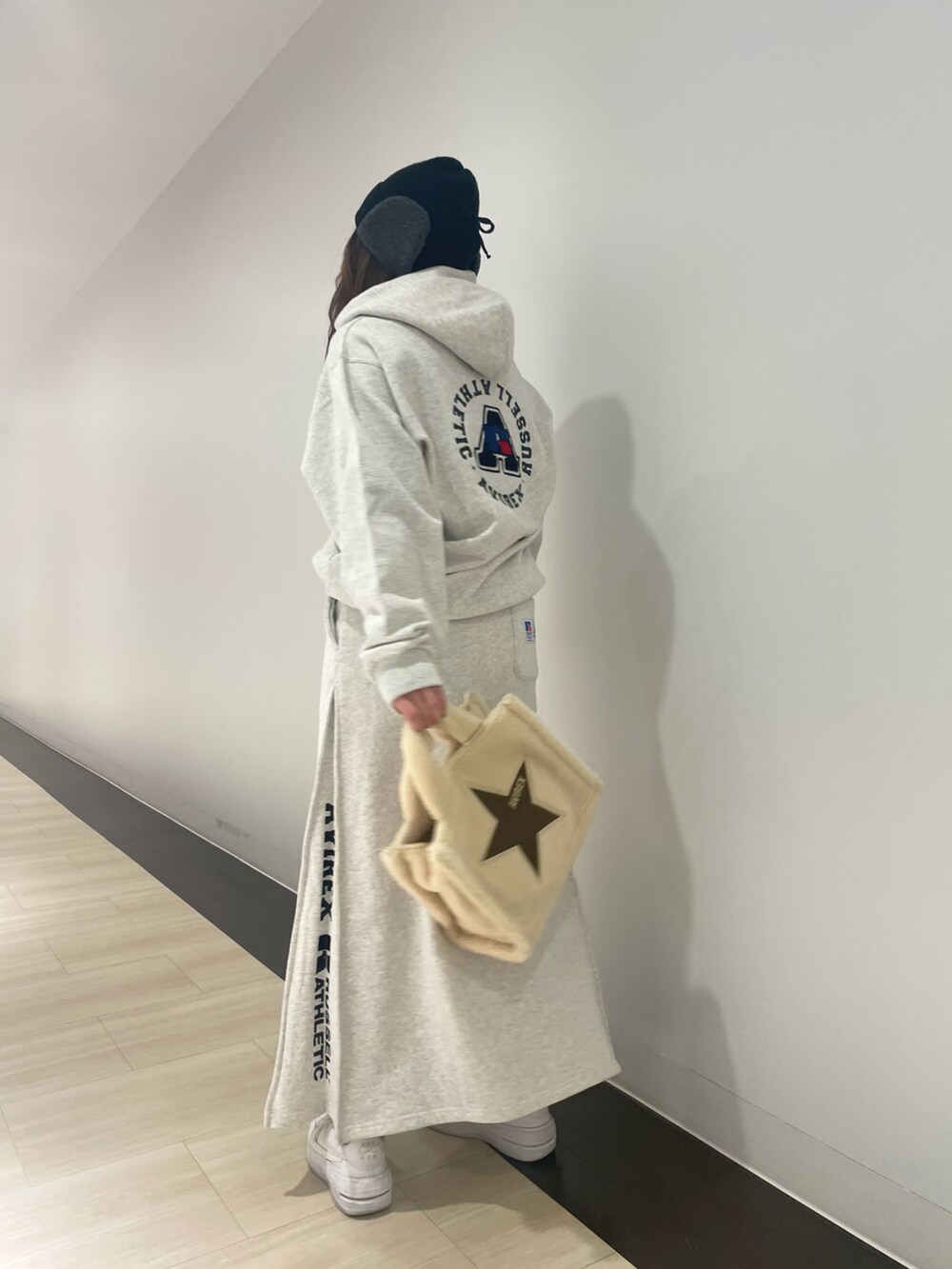 グレー系のパーカー、ホワイト系のトートバッグ、ホワイト系のニットキャップ/ビーニーを着用したレディースの冬コーディネートの2枚目の写真