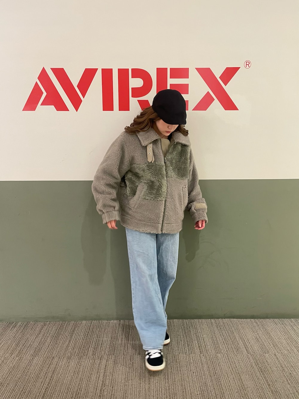 グリーン系のブルゾン、ホワイト系のTシャツ/カットソー、ブラック系のハンチング/ベレー帽を着用したレディースの秋コーディネートの2枚目の写真