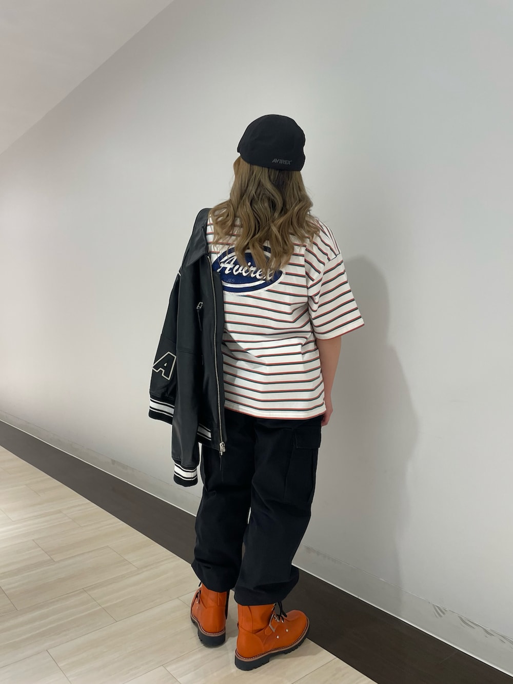 ブラック系のカーゴパンツ、ピンク系のTシャツ/カットソー、ブラック系のスタジャンを着用したレディースの春コーディネートの2枚目の写真