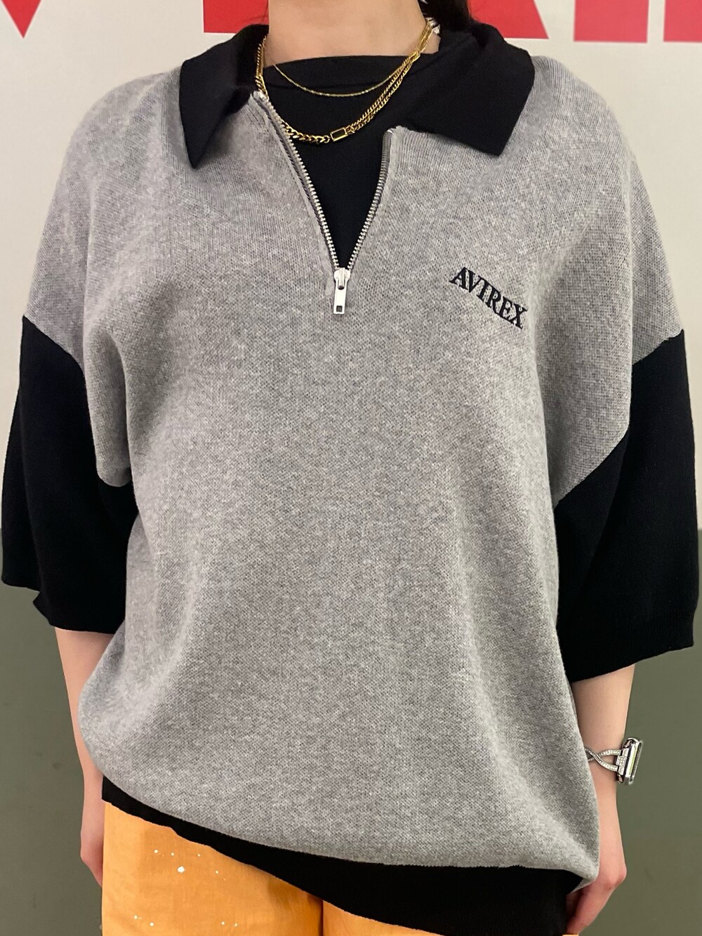 オレンジ系のデニムパンツ、グレー系のニット/セーター、ブラック系のTシャツ/カットソーを着用したレディースの夏コーディネートの3枚目の写真