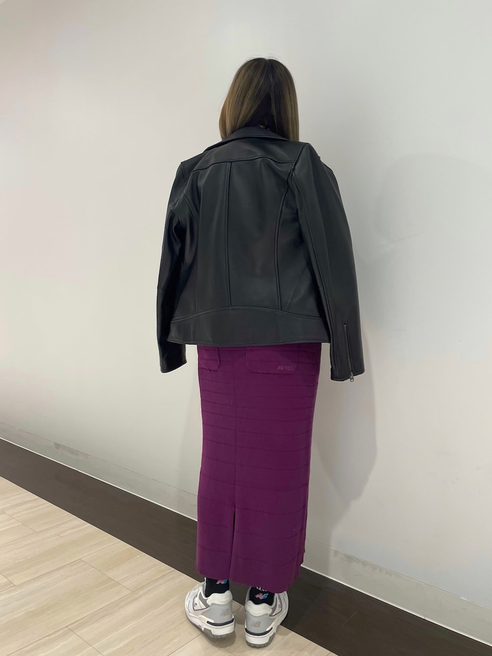 ブラック系のライダースジャケット、パープル系のスカート、ホワイト系のスウェットを着用したレディースの春コーディネートの2枚目の写真