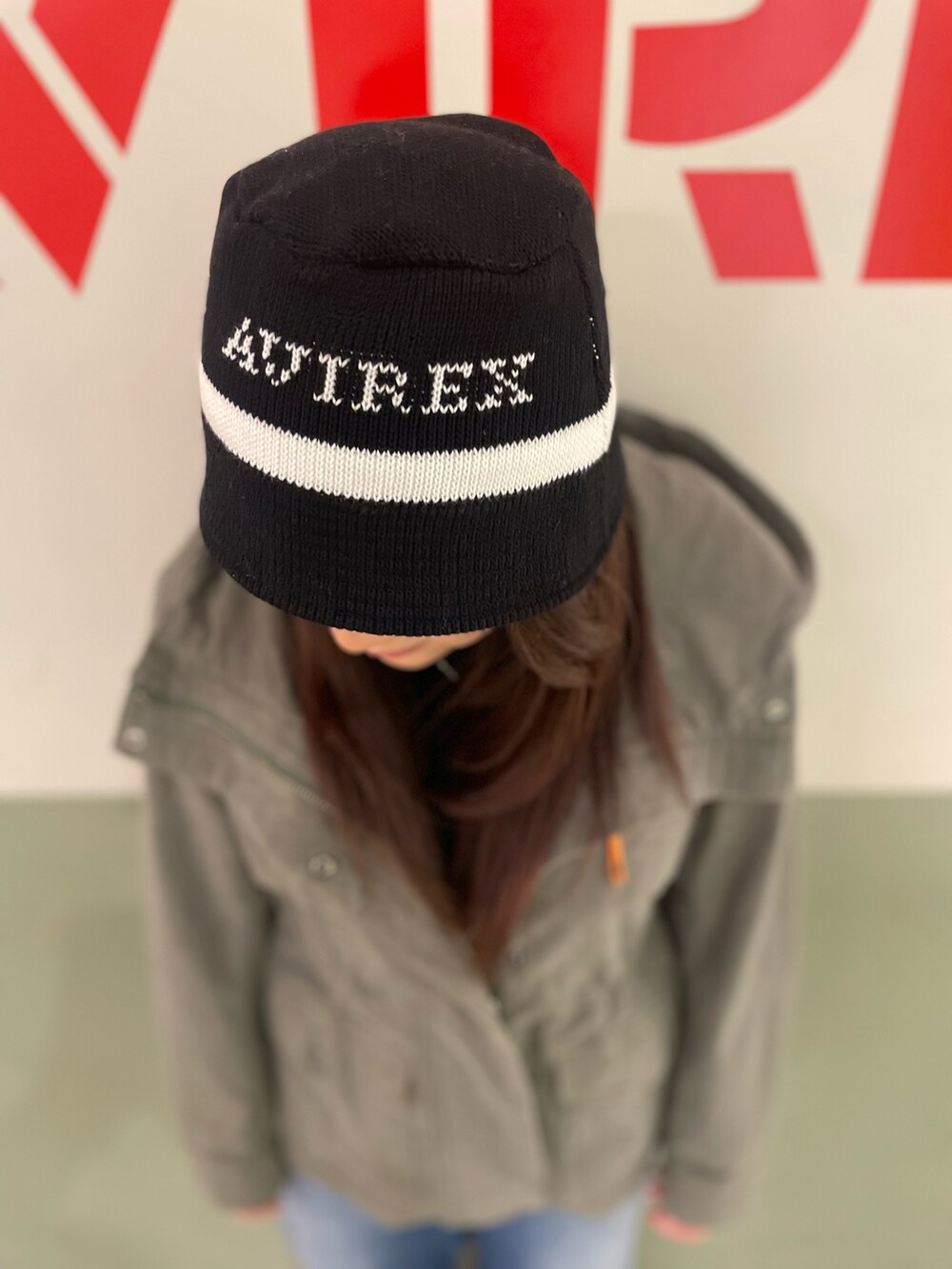 ブルー系のデニムパンツ、グリーン系のその他アウター、ブラック系のハットを着用したレディースの冬コーディネートの3枚目の写真