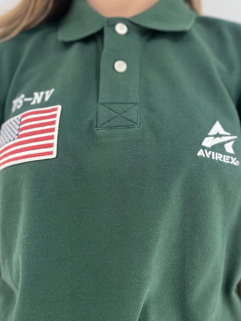 グリーン系のスカート、ブラック系のショルダーバッグ、グリーン系のポロシャツを着用したレディースの春コーディネートの3枚目の写真