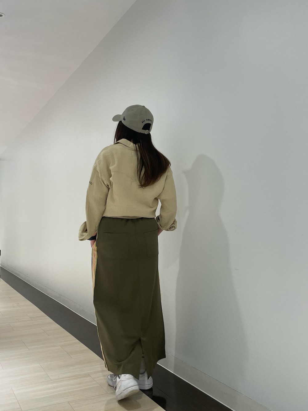 ホワイト系のTシャツ/カットソー、グリーン系のスカート、ベージュ系のシャツ/ブラウスを着用したレディースの春コーディネートの2枚目の写真