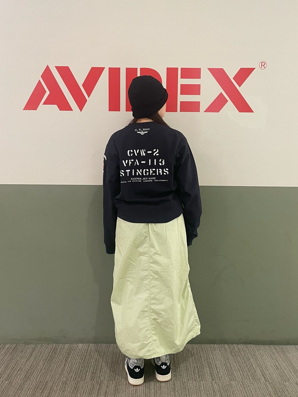 ブルー系のTシャツ/カットソー、グリーン系のスカート、ブルー系のニットキャップ/ビーニーを着用したレディースの冬コーディネートの2枚目の写真