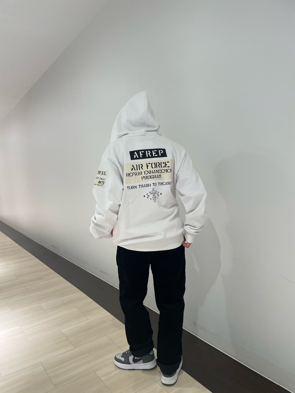 オレンジ系のTシャツ/カットソー、ブラック系のその他パンツ、ホワイト系のパーカーを着用したレディースの秋コーディネートの3枚目の写真