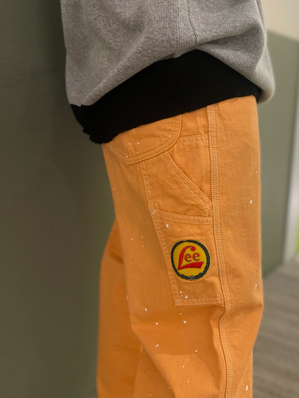 オレンジ系のデニムパンツ、グレー系のニット/セーター、ブラック系のTシャツ/カットソーを着用したレディースの夏コーディネートの4枚目の写真